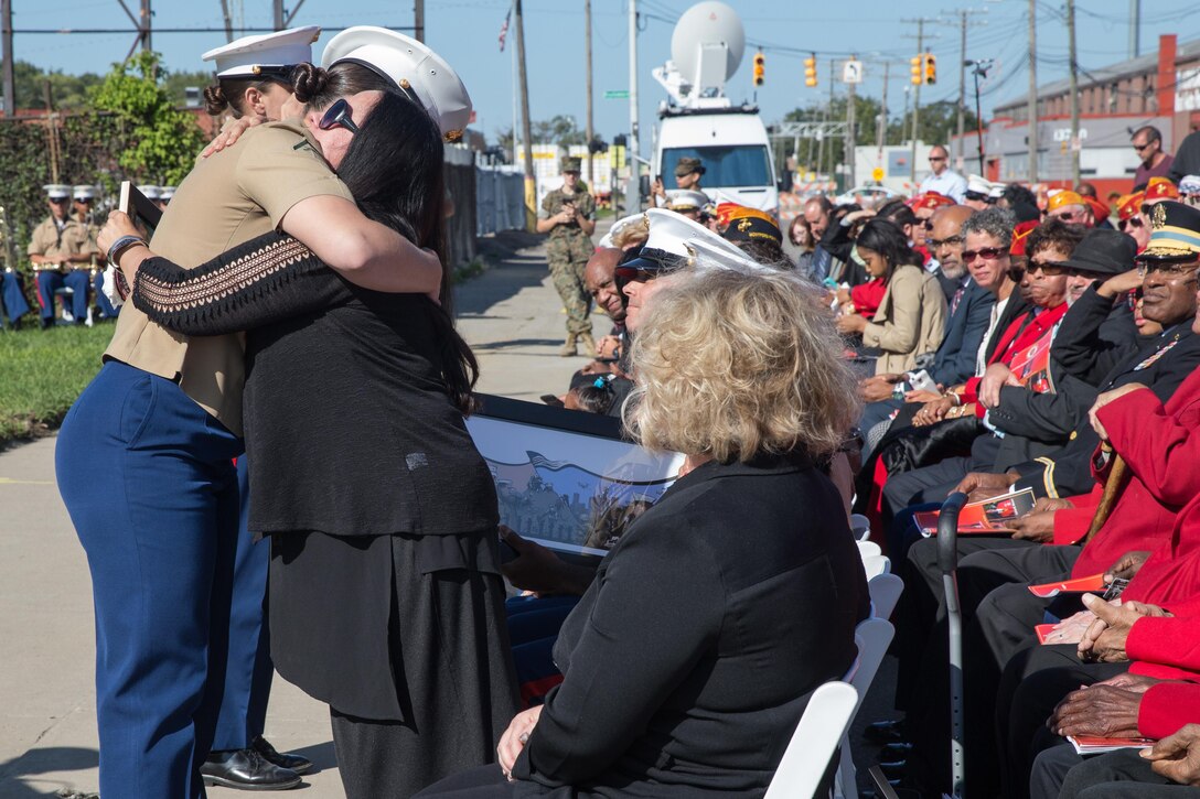 U.S. Marine Corps Lance Cpl. Meghan Millot, a reprographics specialist, assigned to the mural team, hugs Sherry Jennings-Kevianne, widow of Sgt. Julian Kevianne, during Marine Week Detroit, Sept. 9, 2017. Marine Week Detroit is a chance to connect with our Marines, Sailors, veterans and their families from different generations. (U.S. Marine Corps photo by Lance Cpl. Danny Gonzalez)