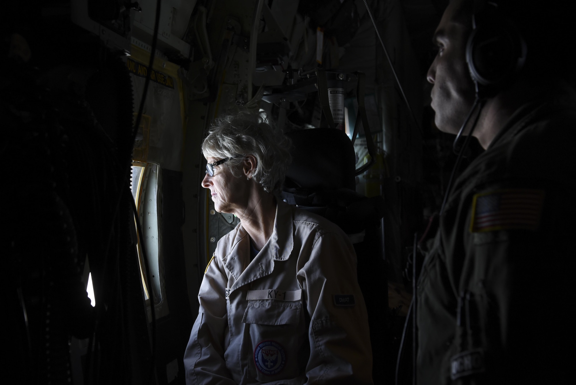(From left) Scar Padgett, KN-1 Disaster Medical Assistance Team registered nurse, and Staff Sgt. Efrain Huereque, 41st Airlift Squadron loadmaster, glance out of a C-130J headed to Orlando International Airport, Fla., mid-flight Sept. 9, 2017. The 41st AS stationed at Little Rock Air Force Base, Ark., delivered state Disaster Medical Assistance Teams and U.S. Public Health Rapid Deployment Force personnel to Florida to prepare for Hurricane Irma relief efforts. (U.S. Air Force photo by Senior Airman Mercedes Taylor)