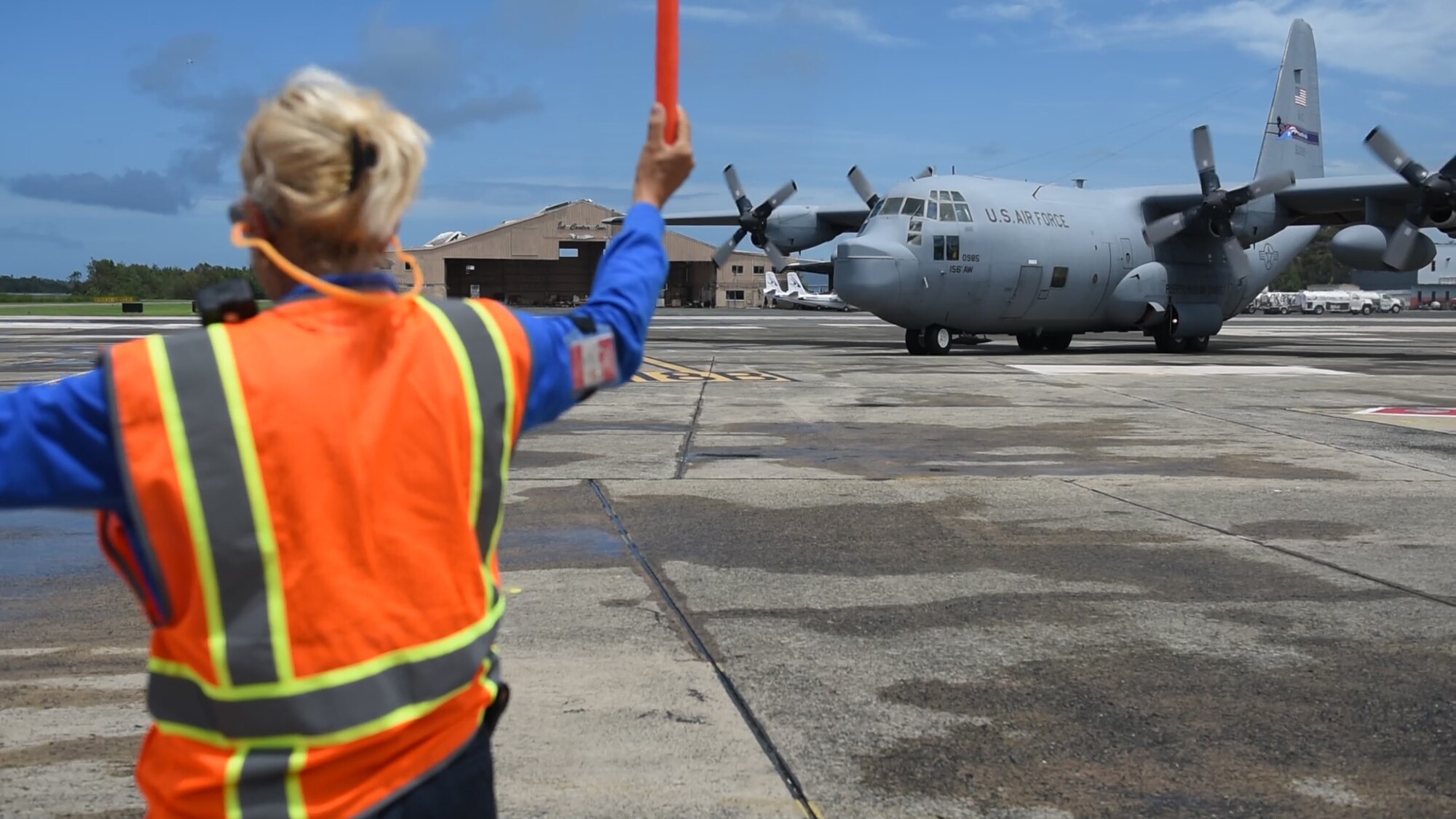 A 156th Airlift Wing - Puerto Rico Air National Guard WC-130H Hercules aircraft is marshaled into a parking spot on the Luis Muñoz Marin International Airport in Carolina, Puerto Rico.