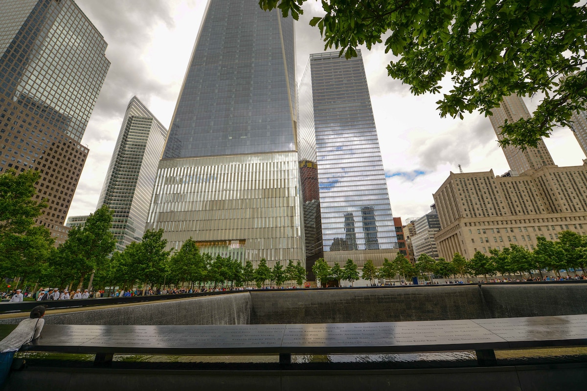 Service members and visitors are seen at the 9/11 memorial plaza.