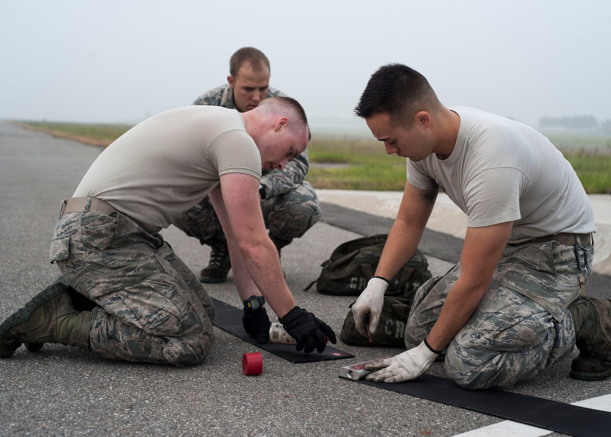U.S. Air Force Airmen assigned to the 8th Civil Engineer Squadron replace the old end of the nylon tape used for the aircraft arresting system at Kunsan Air Base, Republic of Korea, Sept. 9, 2017. The system includes a 1.25-inch steel cable attached to 1,200 feet of the nylon tape wrapped in a large metal reel.  When activated, the reel spins and activates a hydraulic pump which compresses brake pads. Safely bringing the aircraft to a halt in a controlled fashion. (U.S. Air Force photo by Staff Sgt. Victoria H. Taylor)