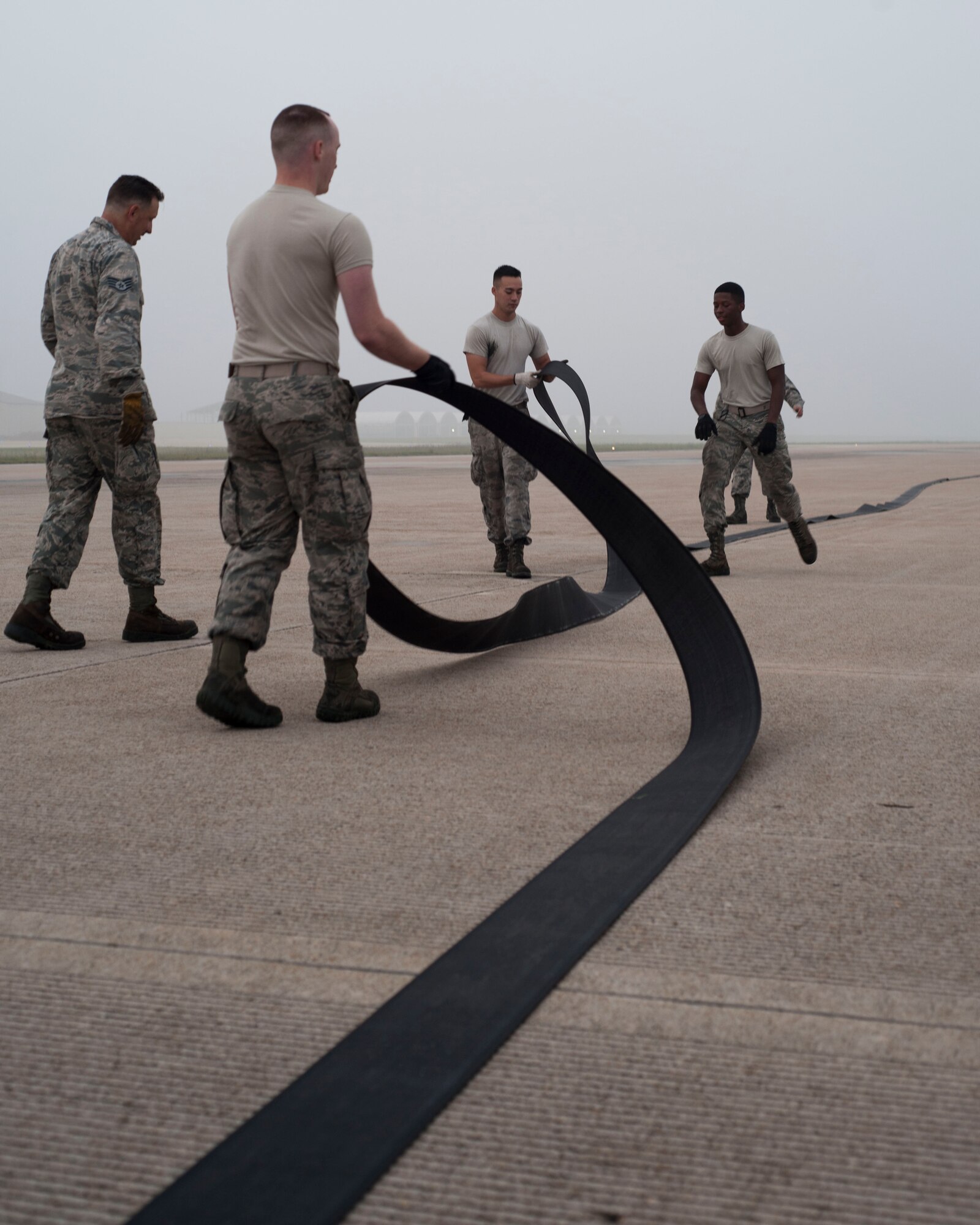 U.S. Air Force Airmen assigned to the 8th Civil Engineer Squadron perform maintenance by extending and flipping the barrier tape on the aircraft arresting system at Kunsan Air Base, Republic of Korea, Sept. 9, 2017. The nylon tape that is used has a lifespan of approximately four years, but needs to be flipped every two years due to normal wear and tear. Civil Engineers perform this maintenance to prevent the tape from improperly snapping and potentially causing severe damage to the aircraft in the event of an in-flight emergency. (U.S. Air Force photo by Staff Sgt. Victoria H. Taylor)