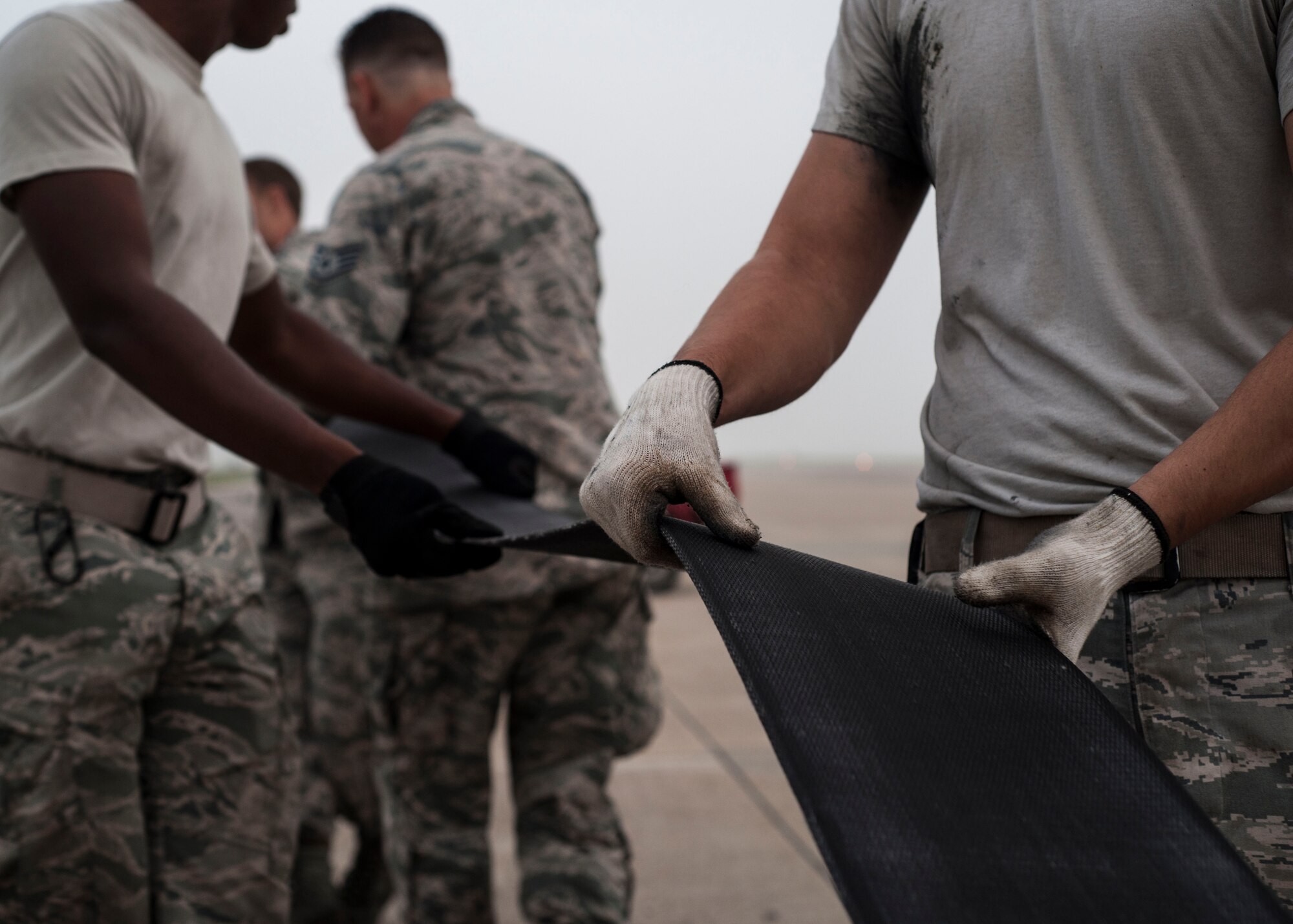 U.S. Air Force Airmen assigned to the 8th Civil Engineer Squadron perform maintenance by extending and flipping the barrier tape on the aircraft arresting system at Kunsan Air Base, Republic of Korea, Sept. 9, 2017.  The aircraft arresting system is a barrier used to catch the arresting hook located on fighter aircraft in the event of a malfunction during landing or take off. There are a total of seven aircraft arresting systems on the airfield requiring daily maintenance performed on them to ensure they are operational. (U.S. Air Force photo by Staff Sgt. Victoria H. Taylor)