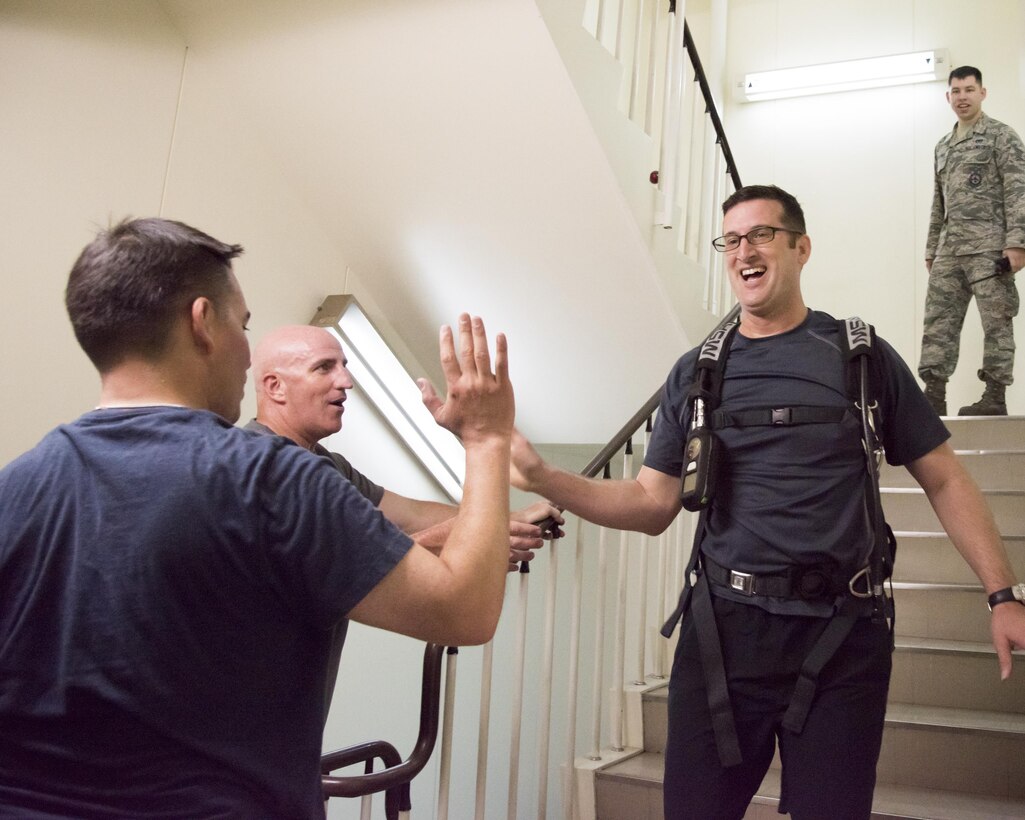 Lt. Col. Jason Jaeger, 374th Airlift Wing director of staff, exchanges a high-five with base leaderships after completing the Sept. 11 Tower Run at Yokota Air Base, Japan, Sept. 8, 2017.