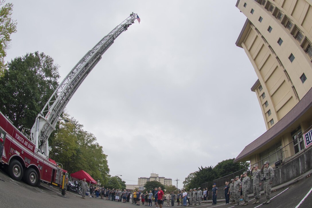 Participants conduct a moment of silence for the emergency responders who lost their lives on Sept. 11, before the Tower Run at Yokota Air Base, Japan, Sept. 8, 2017.