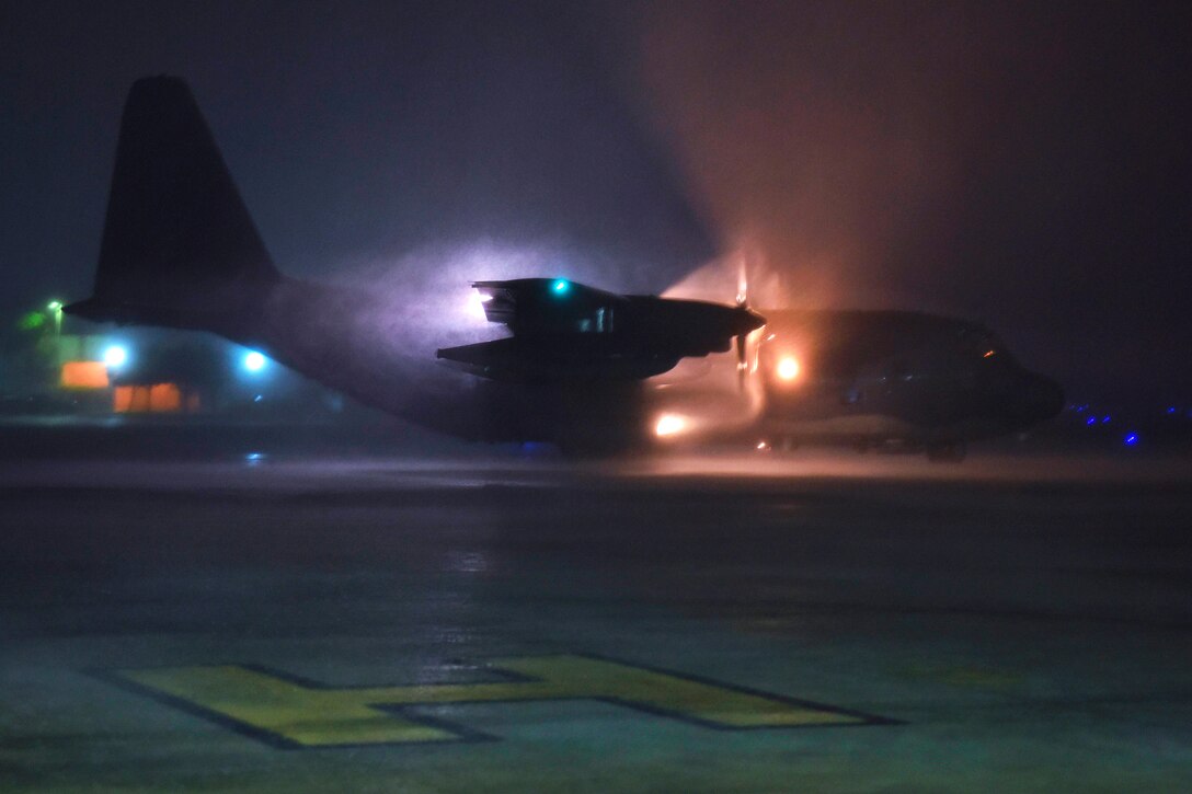 A plane prepares to take off from a runway at night.