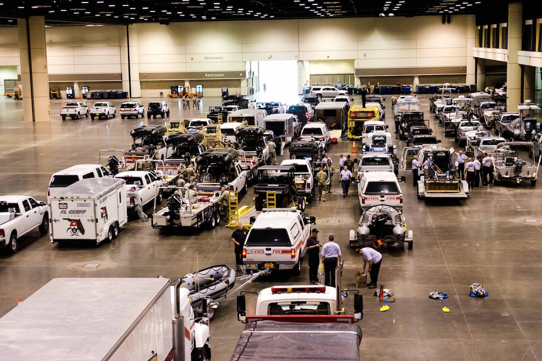 Groups of people and emergency vehicle congregate in an indoor facility.