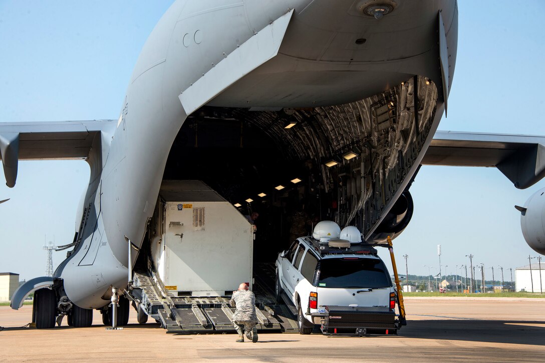 Airmen upload equipment and supplies onto an aircraft.