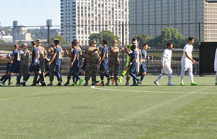 Soldiers assigned to the 354th MPAD, Coraopolis, Pennsylvania, fist bump members of the Point Park University's men's soccer team during a military appreciation game in Pittsburgh September 9, 2017. The 354th MPAD planned a training scenario that allowed the soldiers to practice photography and videography during the game.