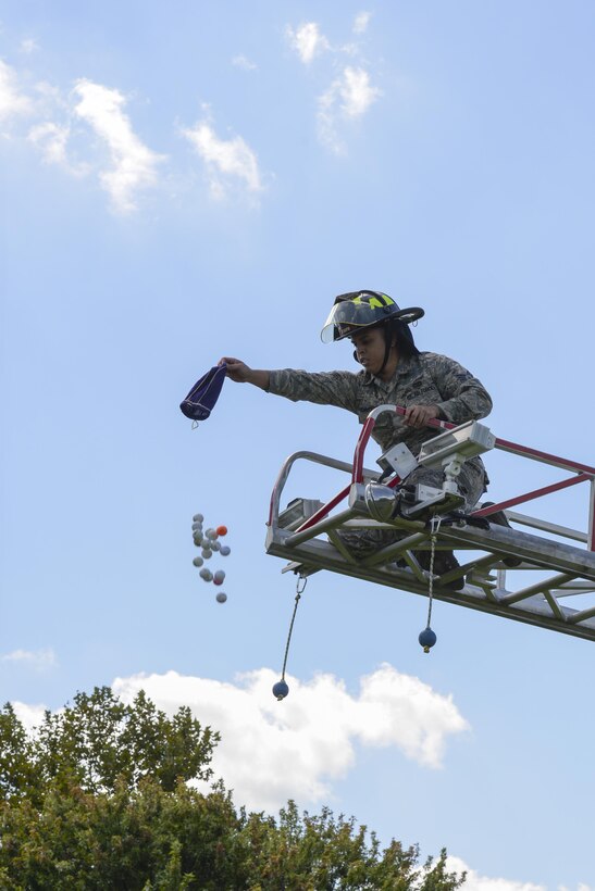 Senior Airman Wilson Rodriguez, 436th Civil Engineer Squadron firefighter, drops numbered golf balls from the extended ladder of a firetruck Sept. 7, 2017, during the Bluesuiters’ Golf Tournament at Eagle Creek Golf Course on Dover Air Force Base, Del. Participants had the option to purchase a ball before the tournament to compete in the ball drop, with the chance of winning 50 percent of the proceeds if their ball landed closest to, or in the whole. (U.S. Air Force photo by Staff Sgt. Aaron J. Jenne)