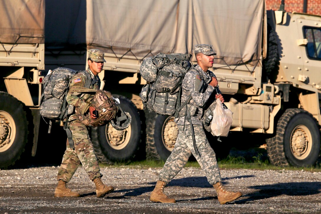 Soldiers prepare gear and light medium tactical vehicles.