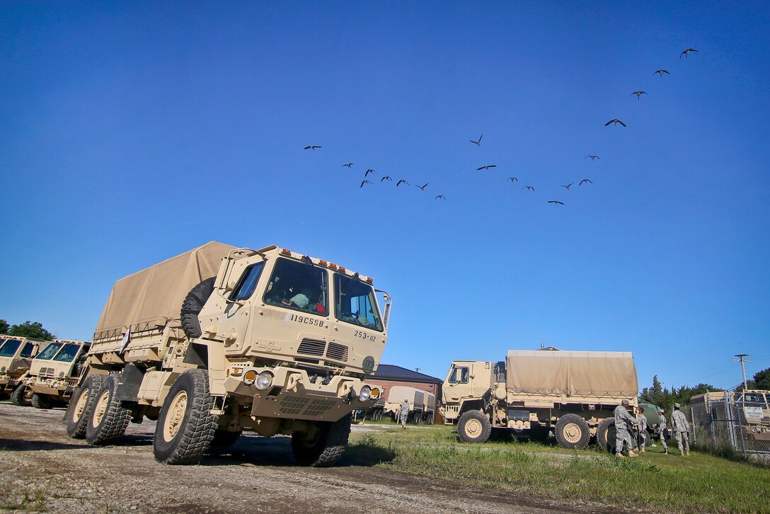 Soldiers prepare their gear and light medium tactical vehicles