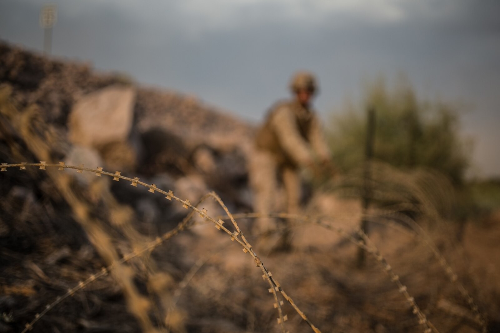 A U.S. Marine with Bridge Company, 7th Engineer Support Battalion, 1st Marine Logistics Group, lays down concertina wire during Exercise Deep Strike II at Blythe, Calif., Sept.6, 2017. Concertina wire is strategically placed and used to simulate setting up a forward operating base (FOB) while deployed. The concertina wire and other defensive barriers are used keep unknown persons out of the FOB and to control access. (U.S. Marine Corps photo by Lance Cpl. Timothy Shoemaker)