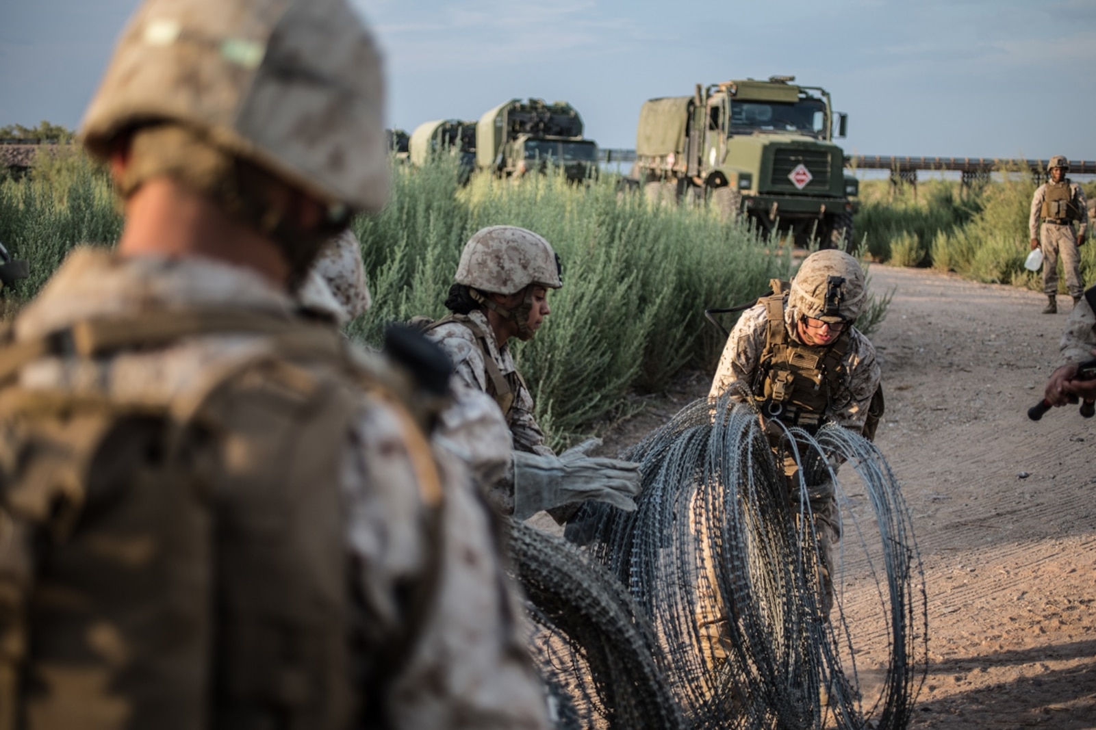 U.S. Marines with Bridge Company, 7th Engineer Support Battalion, 1st Marine Logistics Group, prepare to move concertina wire to various locations during Exercise Deep Strike II at Blythe, Calif., Sept. 6, 2017. Concertina wire is strategically placed and used to simulate setting up a forward operating base (FOB) while deployed. The concertina wire and other defensive barriers are used keep unknown persons out of the FOB and to control access. (U.S. Marine Corps photo by Lance Cpl. Timothy Shoemaker)