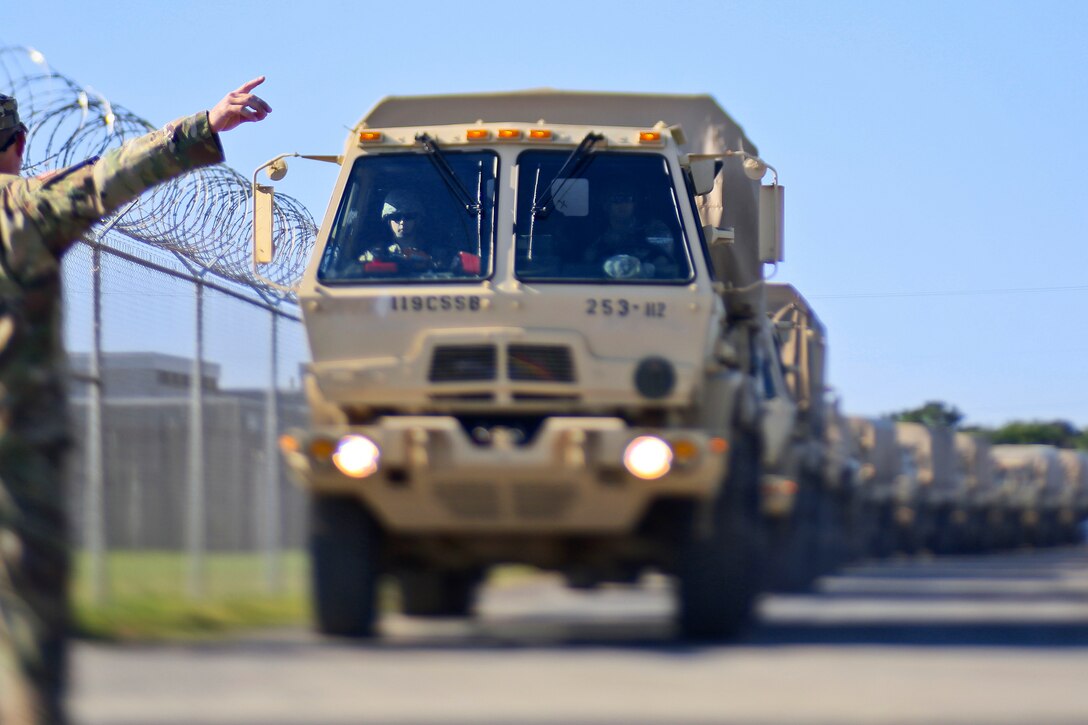 Soldiers drive a light medium tactical vehicles in a convoy