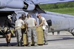 Members of the 164th Logistics Readiness Squadron, Tennessee Air National Guard, and a US Navy Petty Officer 2nd Class Aviation Warfare Specialist, load Federal Emergency Management Agency emergency rations onto a UH-60L Black Hawk helicopter at an air terminal near St. Croix’s airport, Sept. 9.