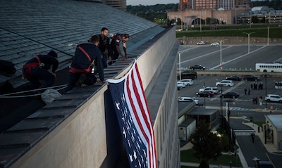 Pentagon workers unfurl a large American flag over the west side of the Pentagon at sunrise, Sept. 11, 2017, on the 16th anniversary of the 9/11 terrorist attacks. During the attacks, 184 people were killed when American Airlines Flight 77 crashed into the western side of the Pentagon near Corridor 4. DoD photo by Air Force Tech. Sgt. Brigitte N. Brantley