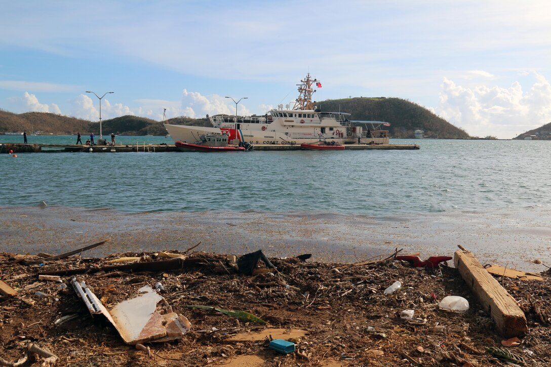 A Coast Guard ship is docked near shore.