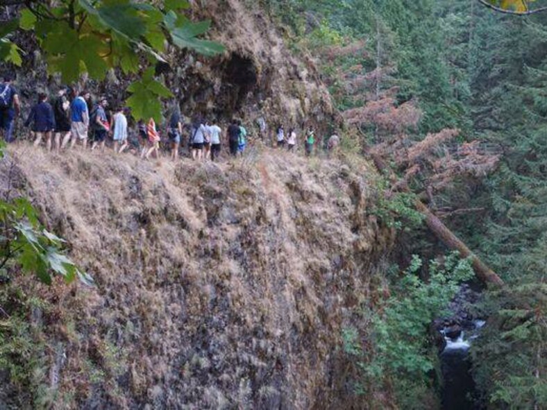 TeHikers head away from the Eagle Creek Trail fire in the Columbia River Gorge near Portland, Ore., on Sept. 2, 2017.A large portion of the hike was on narrow trails along high cliffs. Approximately 150 hikers were led to safety aided by Tech. Sgt. Robert Dones, 349th Medical Squadron surgica technician. (U.S. Air Force courtesy photo provided by Sarah Carlin Ames)