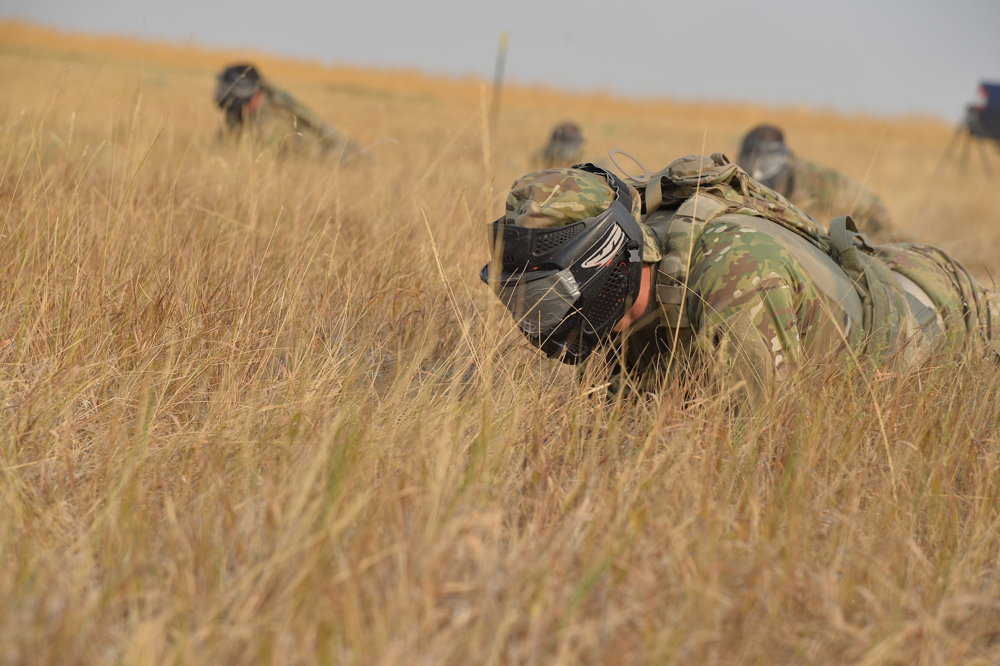 Capt. Joel Bischoff, 341st Security Forces Squadron operations officer, crawls through a field with his team during the annual Aces Cop Combat Challenge Sept. 8, 2017, at Malmstrom Air Force Base, Mont. Teams had to blindly crawl through a field to find an ammo can and verbally guide the rest of the team once it was found my one Airman. (U.S. Air Force photo/Airman 1st Class Daniel Brosam)