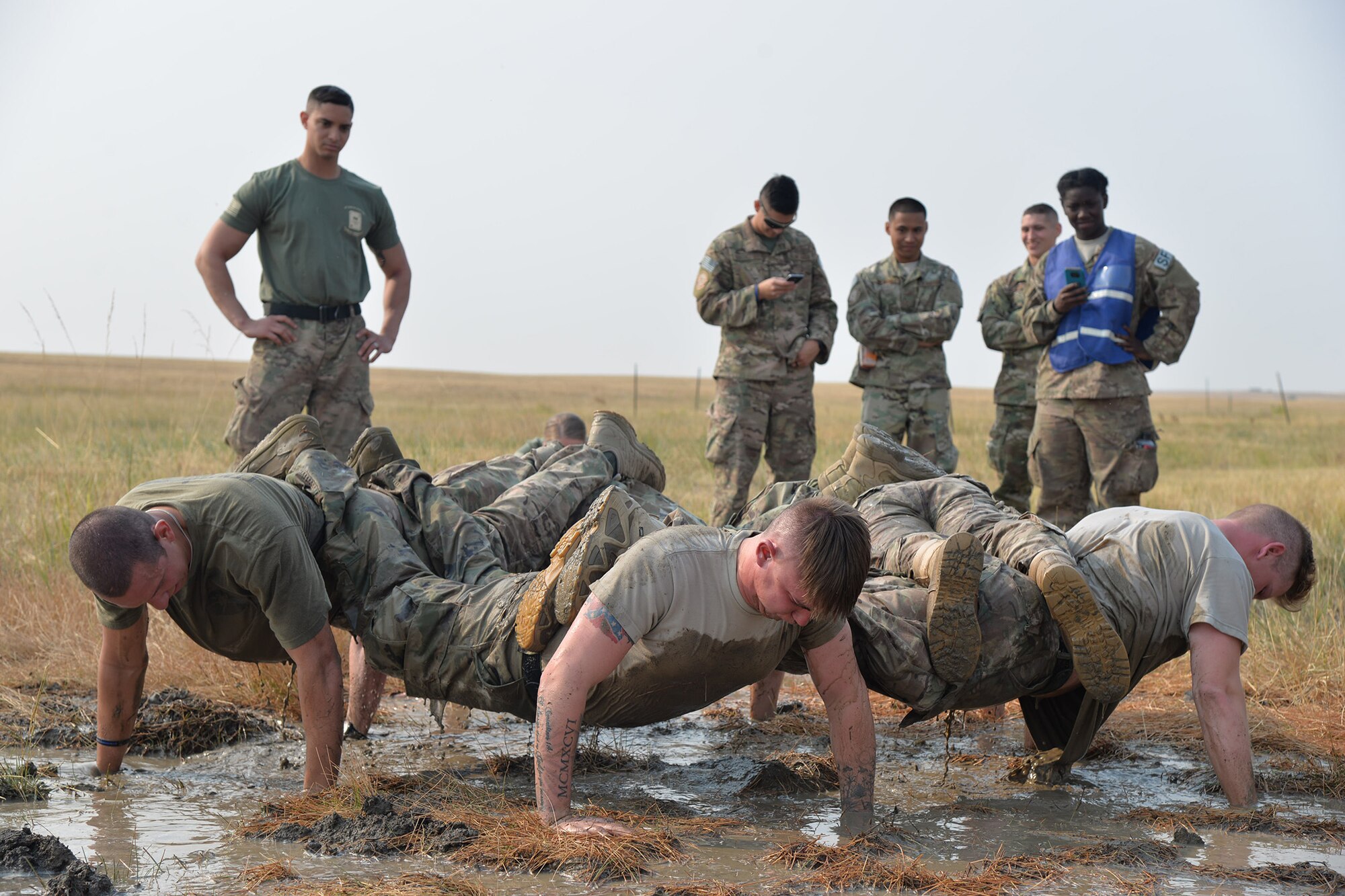 A team of security forces Airmen perform group pushups at the ‘Team Pain’ obstacle during the annual Aces Cop Combat Challenge Sept. 8, 2017, at Malmstrom Air Force Base, Mont. During this obstacle, teams had to complete as many group pushups as possible within two minutes. (U.S. Air Force photo/Airman 1st Class Daniel Brosam)