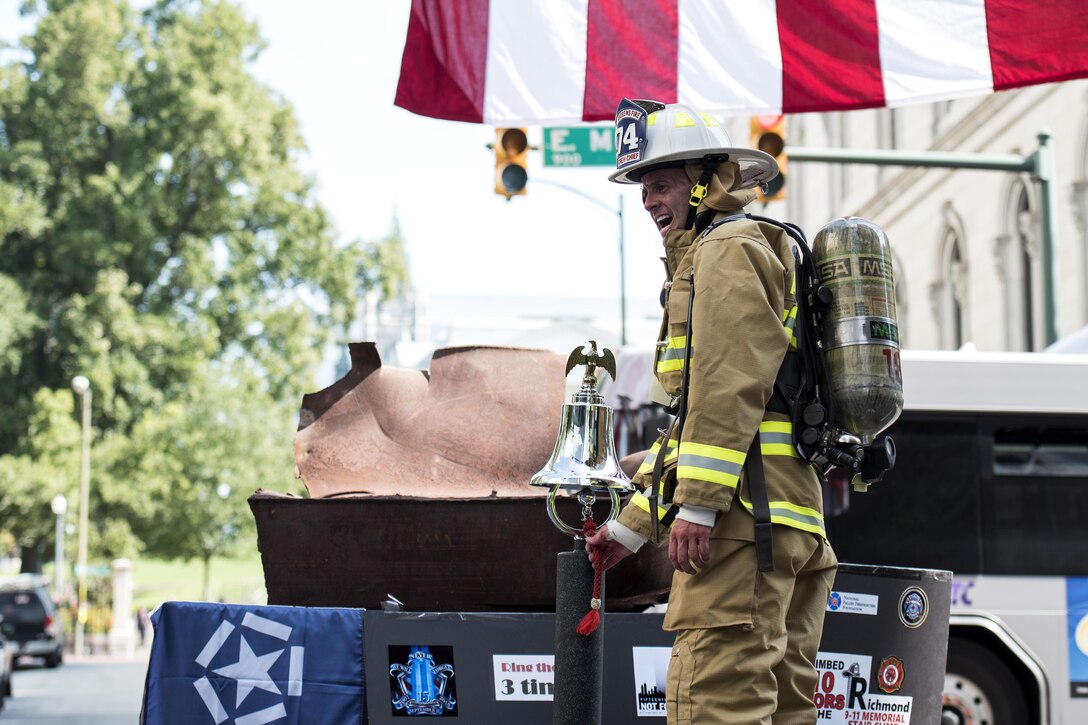 Col. E. John Teichert, 11th Wing and Joint Base Andrews commander, rings a fire bell as he says aloud the name of the first responder he was representing