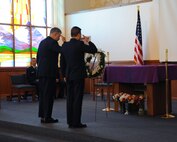 Chaplains (Maj.) Joseph Fisher and (Capt.) Charles Kim, 341st Missile Wing, salute after placing a wreath of flowers on an easel as a tribute to those affected by the 9/11 attacks. Members of Malmstrom Air Force Base, Mont., came together Sept, 11, 2017, at the base chapel to remember those who lost their lives during the Sept. 11, 2001, attacks. (U.S. Air Force photo/Christy Mason)