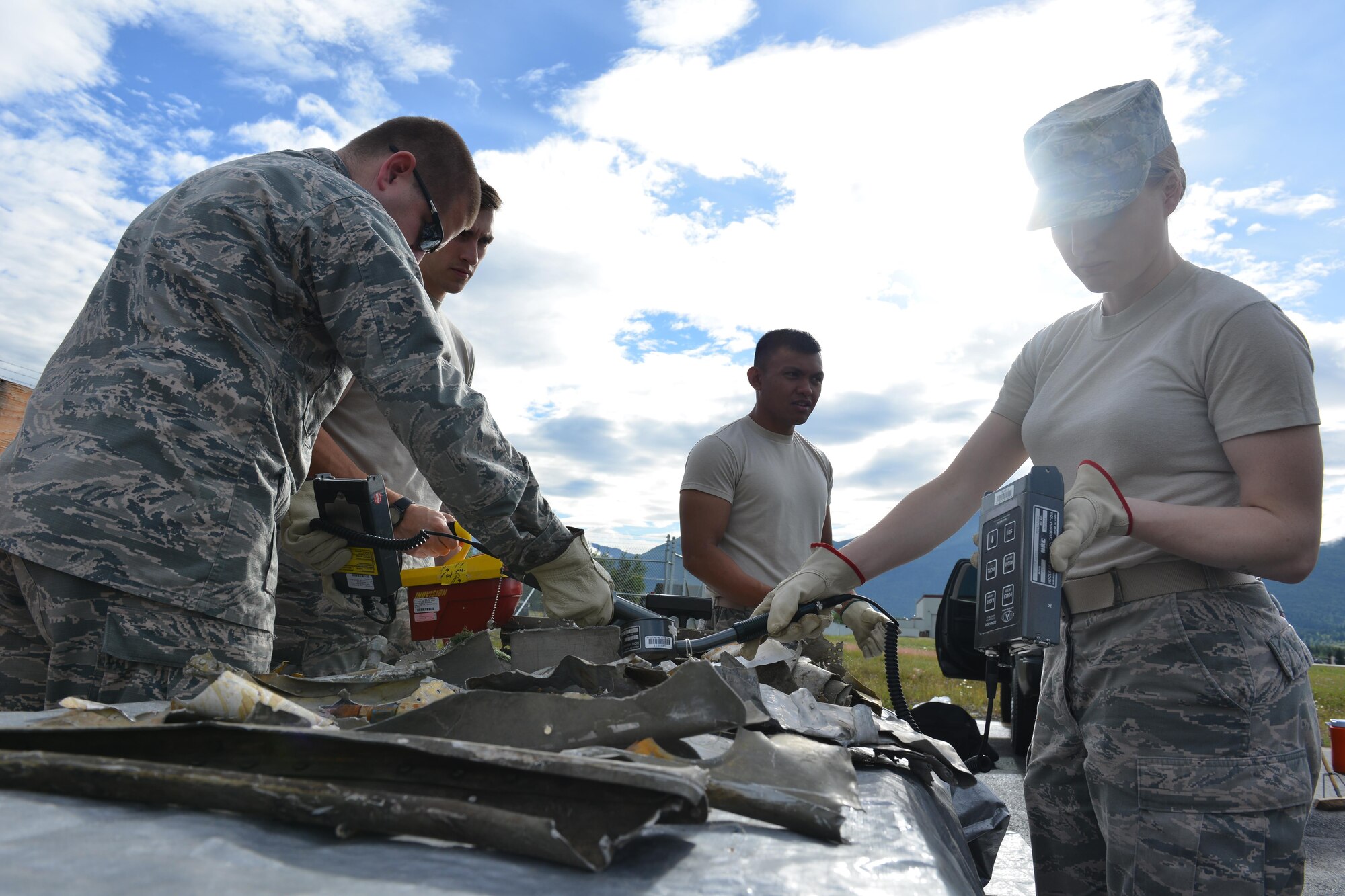 Airmen from the 673d Medical Group's Bioenvironmental Engineering Flight unload scrap metal from shipment boxes on the Bryant Army Airfield July 20, 2017.