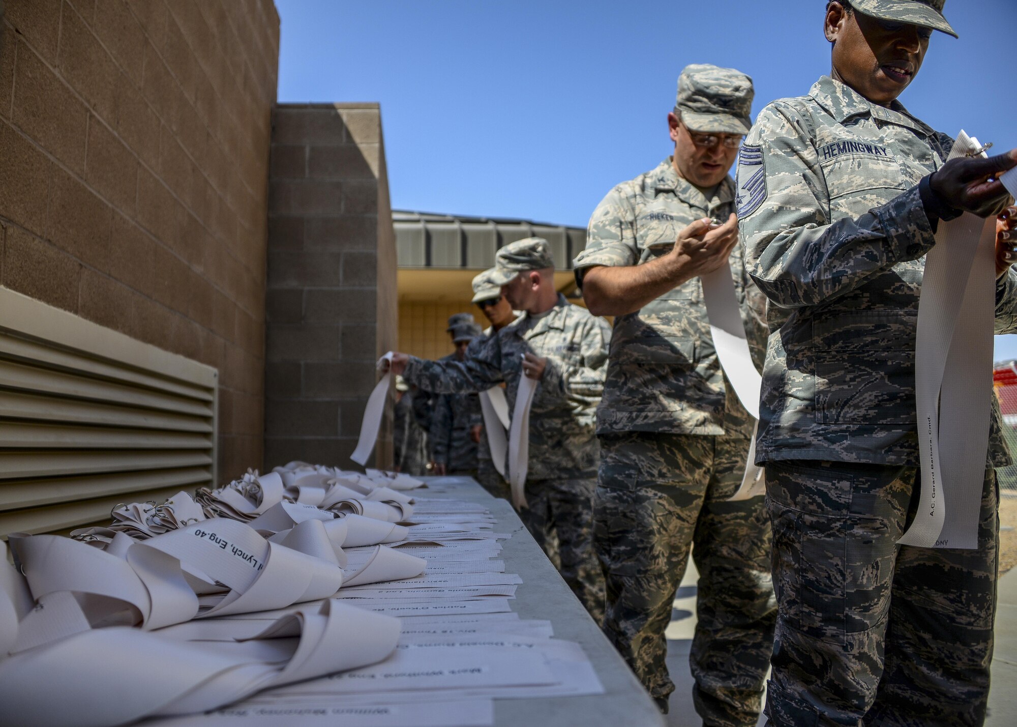 Airmen assigned to the 56th Fighter Wing pick up ribbons before a ten story stair climb Sept. 11, 2017 at Luke Air Force Base, Ariz. The Airmen climbed and descended ten stories of stairs in the air traffic control tower carrying ribbons that contained the names of those who lost their lives during the terrorist attack. (U.S. Air Force photo/Airman 1st Class Caleb Worpel)