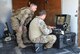 Senior Airman Jared Basham (left) and Staff Sgt. Robert Powell, 9th Civil Engineer Squadron explosive ordnance technicians, use a robot to remotely view a house during Urban Shield