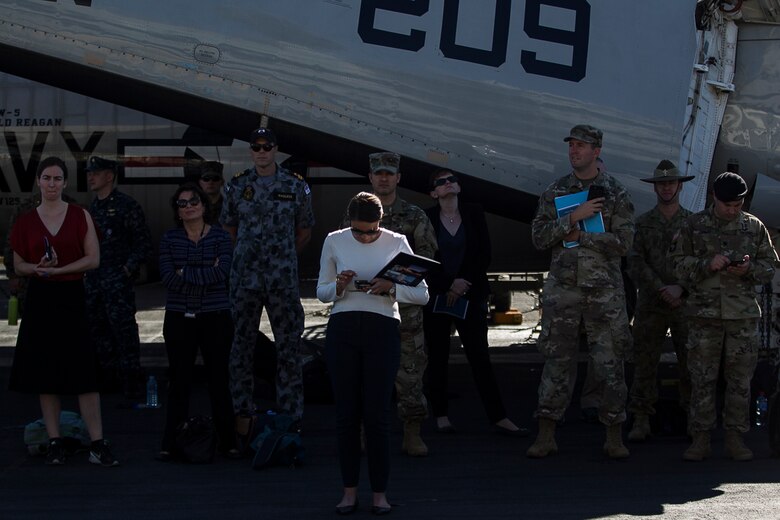 Service members from several partner nations sit atop the flight deck during the closing ceremony of Exercise Talisman Saber 17 aboard the USS Ronald Reagan (CVN 76), ported in Brisbane, Queensland, Australia, July 25, 2017.