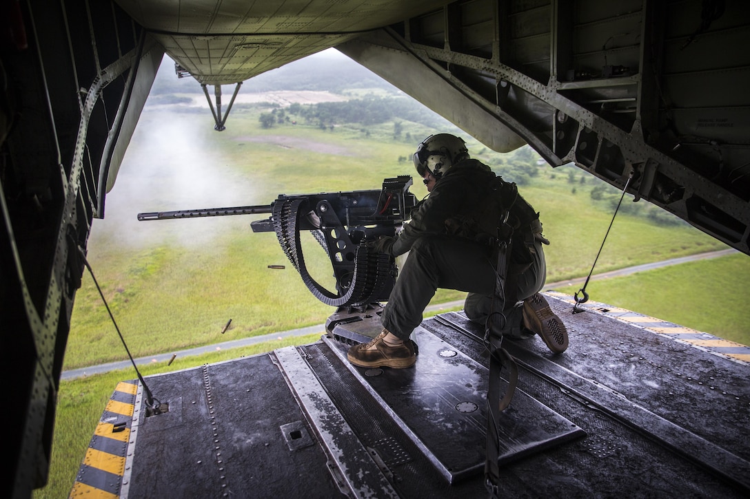 A crew chief fires a Browning M2 .50-caliber machine gun from the back of a CH-53E Super Stallion above Draughon Range near Misawa Air Base, Japan, August 21, 2017, in support of exercise Northern Viper 17. This combined-joint exercise is held to enhance regional cooperation between participating nations to collectively deter security threats. The crew chief is assigned to Marine Heavy Helicopter Squadron 462, Marine Aircraft Group 16, 3rd Marine Aircraft Wing, currently forward deployed under the Unit Deployment Program with Marine Aircraft Group 36, 1st MAW, based out of Okinawa, Japan. (U.S. Marine Corps photo by Lance Cpl. Andy Martinez)