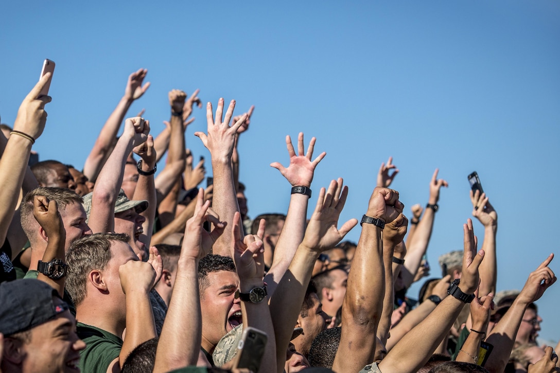 Airmen raise their hands to celebrate their win.