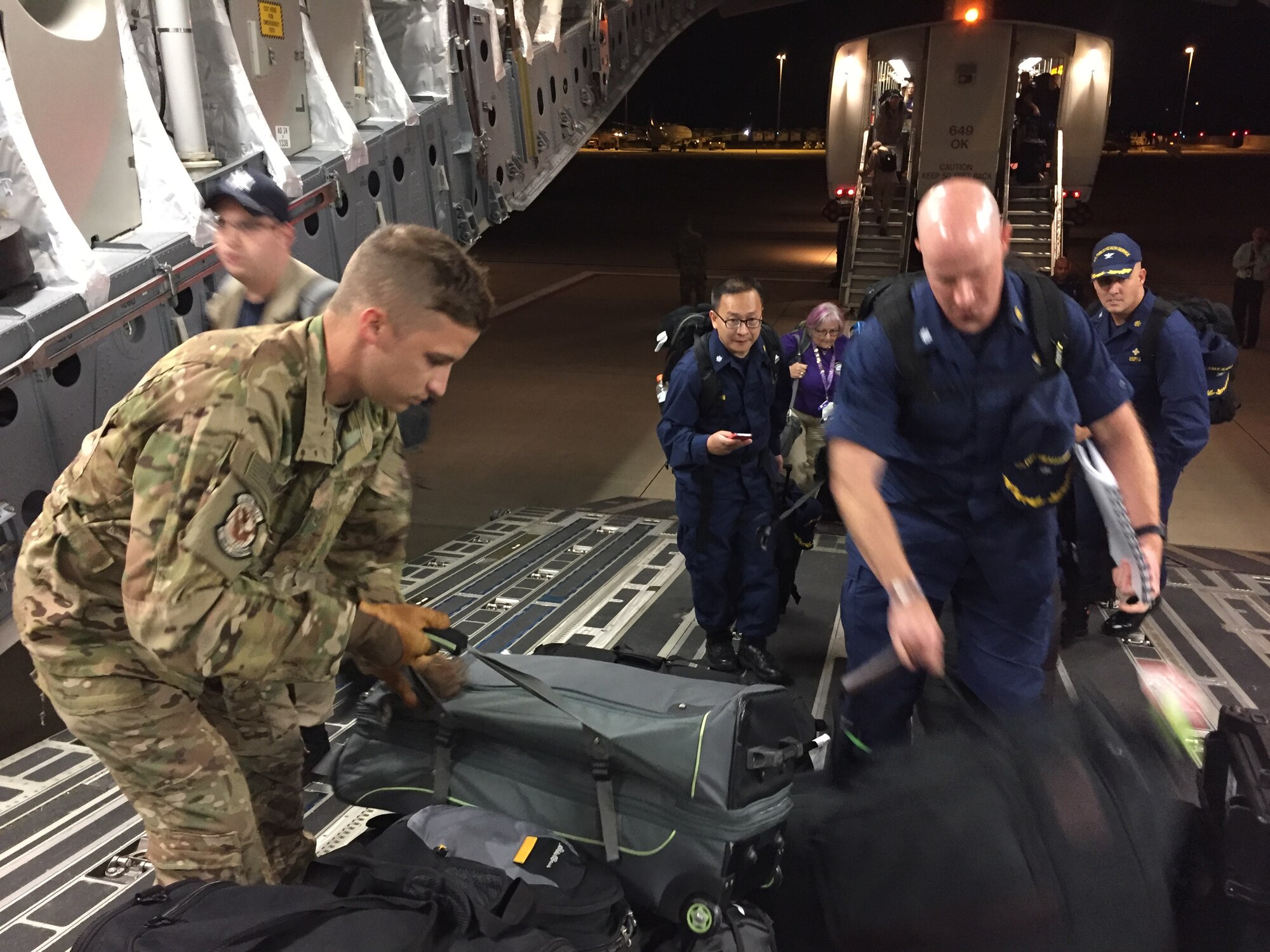 Staff Sgt. Rob Lummus, 15th Airlift Squadron loadmaster, helps medical professionals from Health and Human Services load baggage on a flight from Dulles International  Airport, Washington D.C., to Orlando, Florida, Sept. 9. The mission supported HHS as they coordinate the federal medical and public health medical support to the state of  Florida. Lummus' first exposure to a C-17 came when he was 17-years old volunteering during Hurricane Katrina.