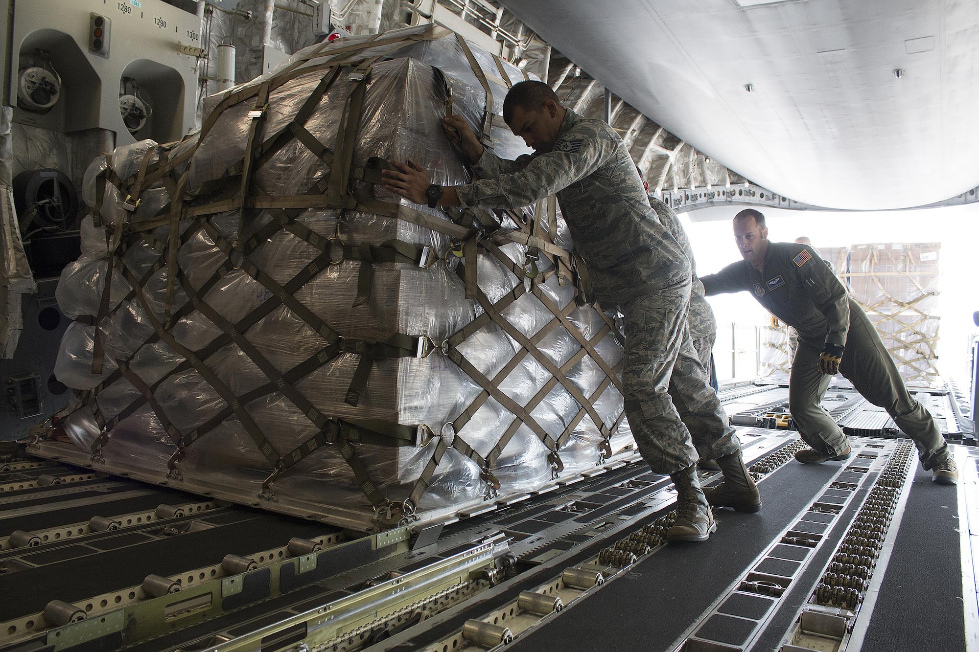 Tech. Sgt. Bryan Ulloa, 445th Force Support Squadron Services Flight services manager, helps Tech. Sgt. Andrew Wagner, 89th Airlift Squadron loadmaster, load cargo on board a 445th Airlift Wing C-17 Globemaster III Monday. Four Airmen from the 445th FSS flew with the cargo that included a pallet of meals ready to eat, a pallet of water and one ISU 90 loaded with cots bound for Homestead Air Reserve Base, Florida. (U.S. Air Force photo/Master Sgt. Patrick O’Reilly