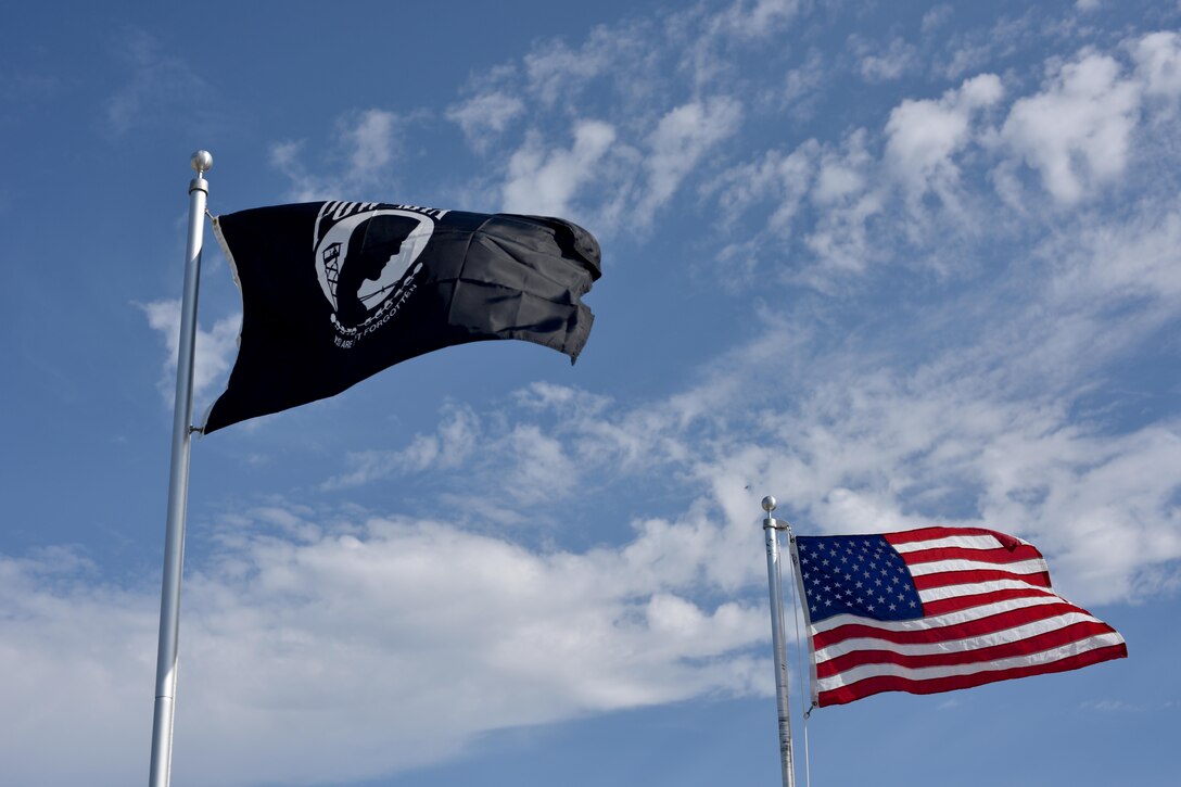 A Prisoners of War and Missing in Action  flag flies next to an American flag during the POW/MIA vigil at the parade field on Goodfellow Air Force Base, Texas, Sept. 8, 2017. Congress ordered prominent display of the POW/MIA flag on POW/MIA Recognition Day and several other national observances, including Armed Forces Day, Memorial Day, Flag Day, Independence Day and Veterans Day. (U.S. Air Force photo by Airman 1st Class Randall Moose/Released)