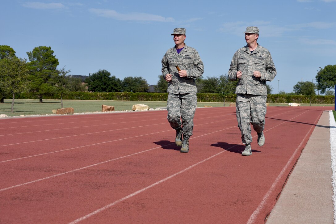 U.S. Air Force Col. Jeffrey Sorrell, 17th Training Wing vice commander, and Chief Master Sgt. Franklin Chism, 17th Mission Support Group superintendent, run during the Prisoners of War and Missing in Action Run at the track on Goodfellow Air Force Base, Texas, Sept. 8, 2017. Sorrell and Chism then began the run while carrying the POW/MIA baton. Participants would then take turns, passing the baton throughout the day. (U.S. Air Force photo by Airman 1st Class Randall Moose/Released)