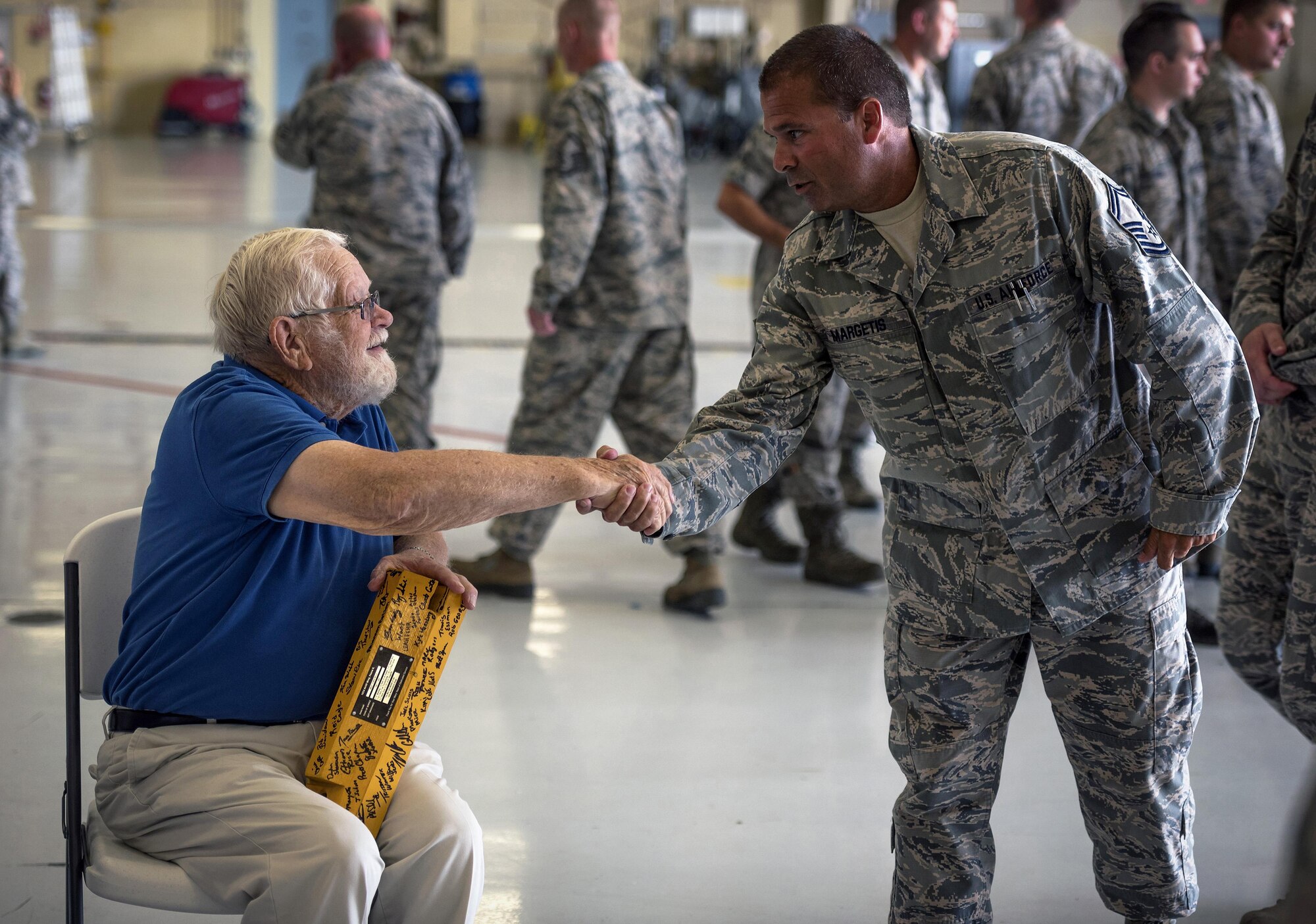 Retired U.S. Air Force Chief Master Sgt. Homer Wells, a former chief of maintenance with the 182nd Tactical Air Support Group, shakes the hand of Senior Master Sgt. Scott Margetis, an aerospace maintenance master with the 182nd Maintenance Squadron, during a ceremony honoring his service in Peoria, Ill., Aug. 24, 2017. Wells enlisted in 1947 and retired in 1984 with 37 years of service with the Illinois Air National Guard. (U.S. Air National Guard photo by Tech. Sgt. Lealan Buehrer)