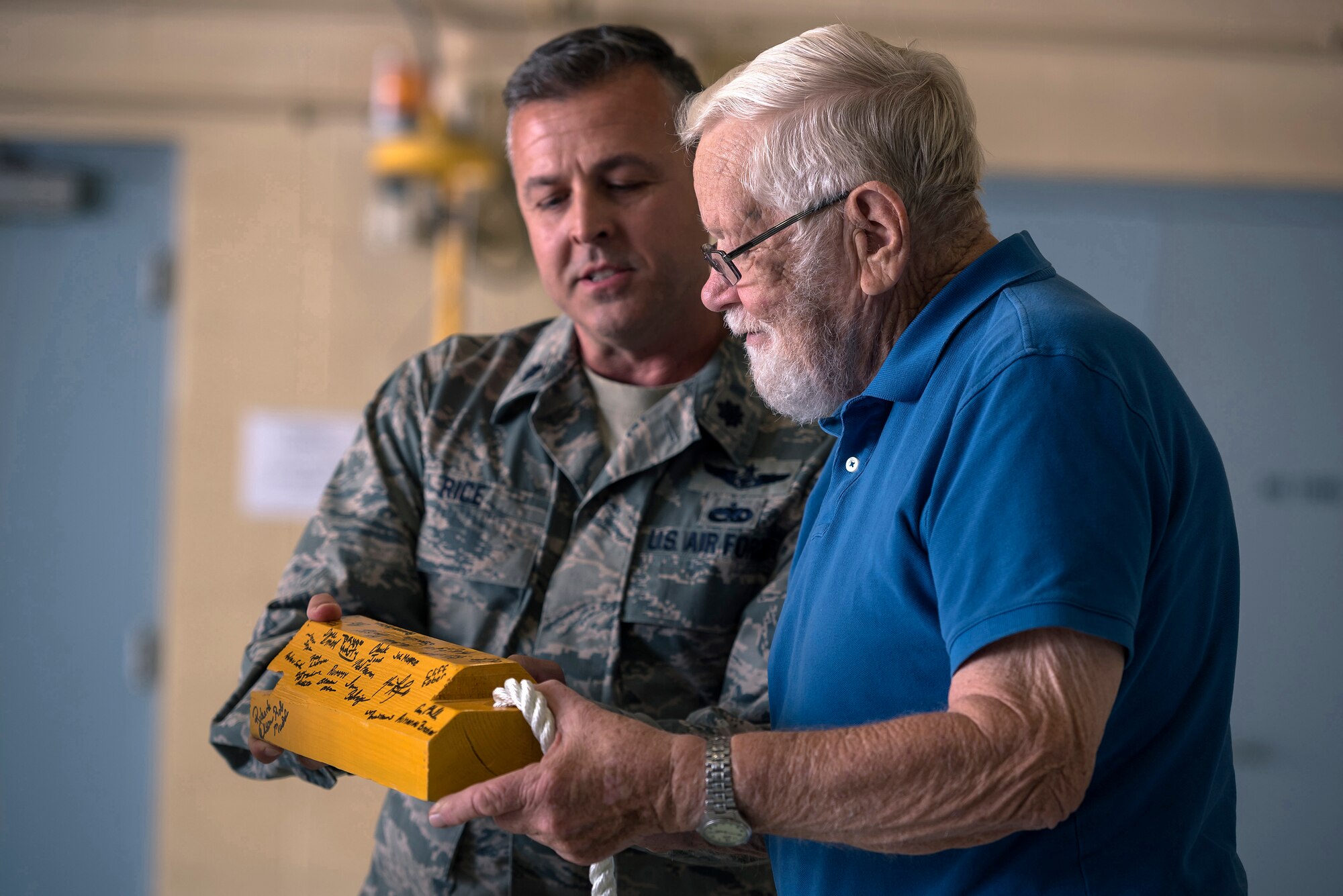 U.S. Air Force Lt. Col. Steven Rice, the deputy commander of the 182nd Maintenance Group, gives retired U.S. Air Force Chief Master Sgt. Homer Wells, a former chief of maintenance with the 182nd Tactical Air Support Group, an aircraft chock signed by the group during a ceremony honoring his service in Peoria, Ill., Aug. 24, 2017. Wells enlisted in 1947 and retired in 1984 with 37 years of service with the Illinois Air National Guard. (U.S. Air National Guard photo by Tech. Sgt. Lealan Buehrer)