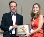 Lauren Cornell, from the U.S. Army Institute of Surgical Research at Joint Base San Antonio-Fort Sam Houston, receives the top honor in the Young Investigator competition at the Military Health System Research Symposium Aug. 30, in Kissimmee, Fla. The award was presented by Dr. Terry M. Rauch, Acting Deputy Assistant Secretary of Defense (Health Affairs) Health Readiness Policy and Oversight.