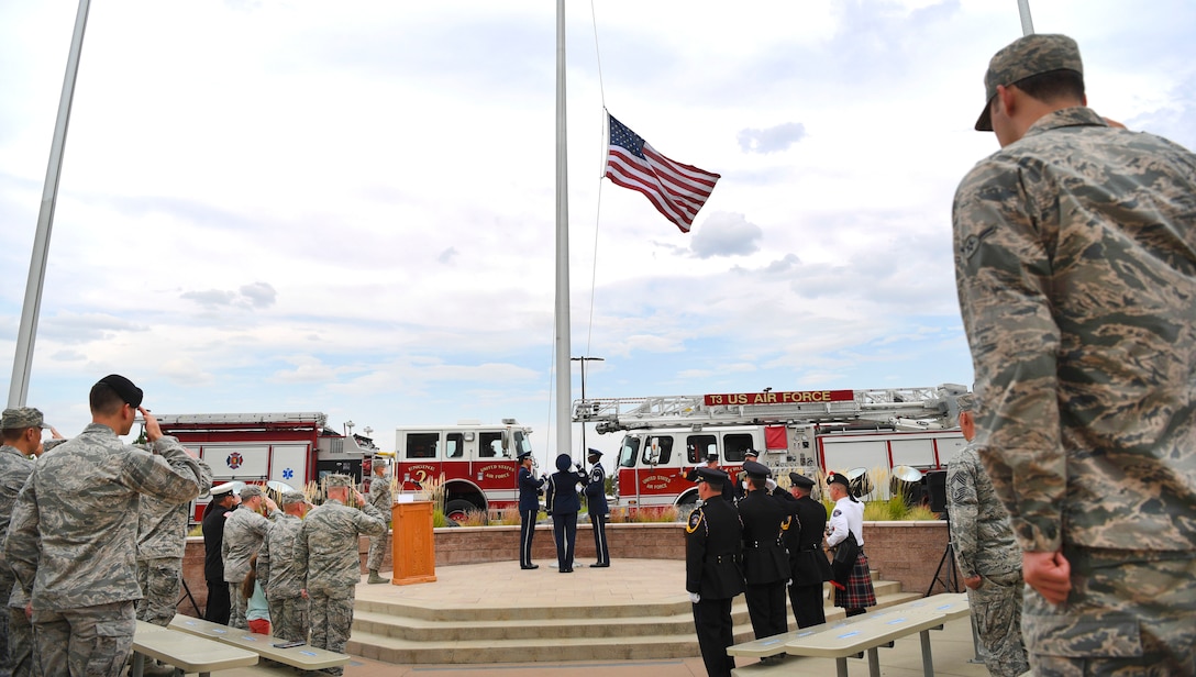Airmen lower the flag before folding it during a Patriot Day, 9/11 remembrance ceremony