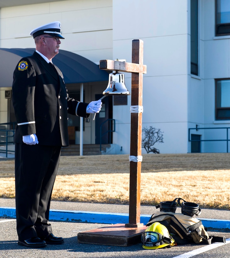 Lt. Thomas Becker, a member of Navy Region Northwest Fire and Emergency Services, tolls the bell in memory of firefighters who lost their lives in the 9/11 attacks
