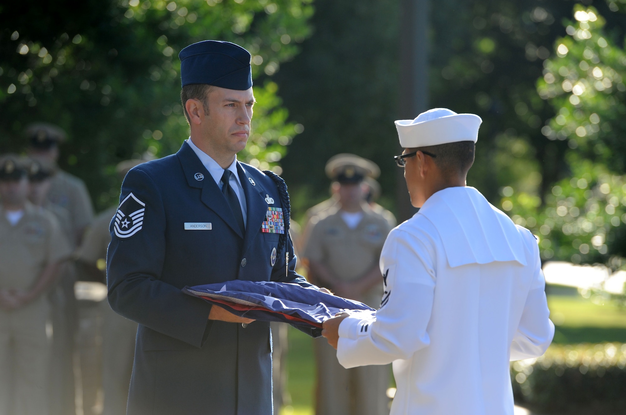 Master Sgt. Joshua Anderson, 81st Training Support Squadron Military Training Leader School instructor supervisor, and U. S. Navy Aviation Electronics Technician First Class Hugo Paez, Center for Naval Aviation Technical Training Unit Keesler student, participate in a U.S. Flag folding ceremony during a 9/11 memorial ceremony hosted by the CNATTU Keesler in front of Alho Manor Sept. 11, 2017, on Keesler Air Force Base, Mississippi. The event honored those who lost their lives during the 9/11 attacks. (U.S. Air Force photo by Kemberly Groue)