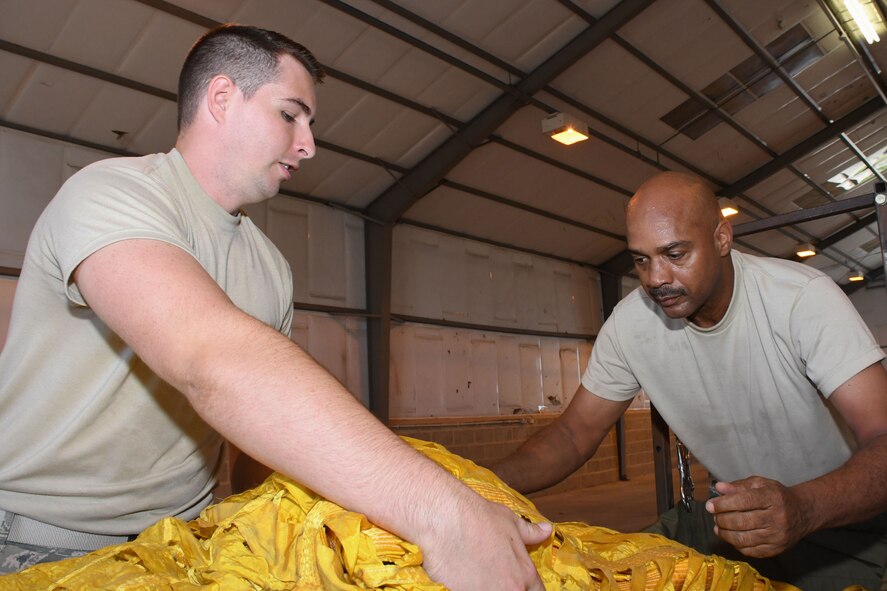 U.S. Air Force Senior Airman Jackson Stogsdill, 307th Operations Support Squadron air flight equipment technician, and Senior Master Sgt. Grady King, 307th Operations Support Squadron air flight equipment section chief, team lift the drag chute of a B-52 Stratofortress at Royal Air Force Fairford, U.K., Aug. 28, 2017.