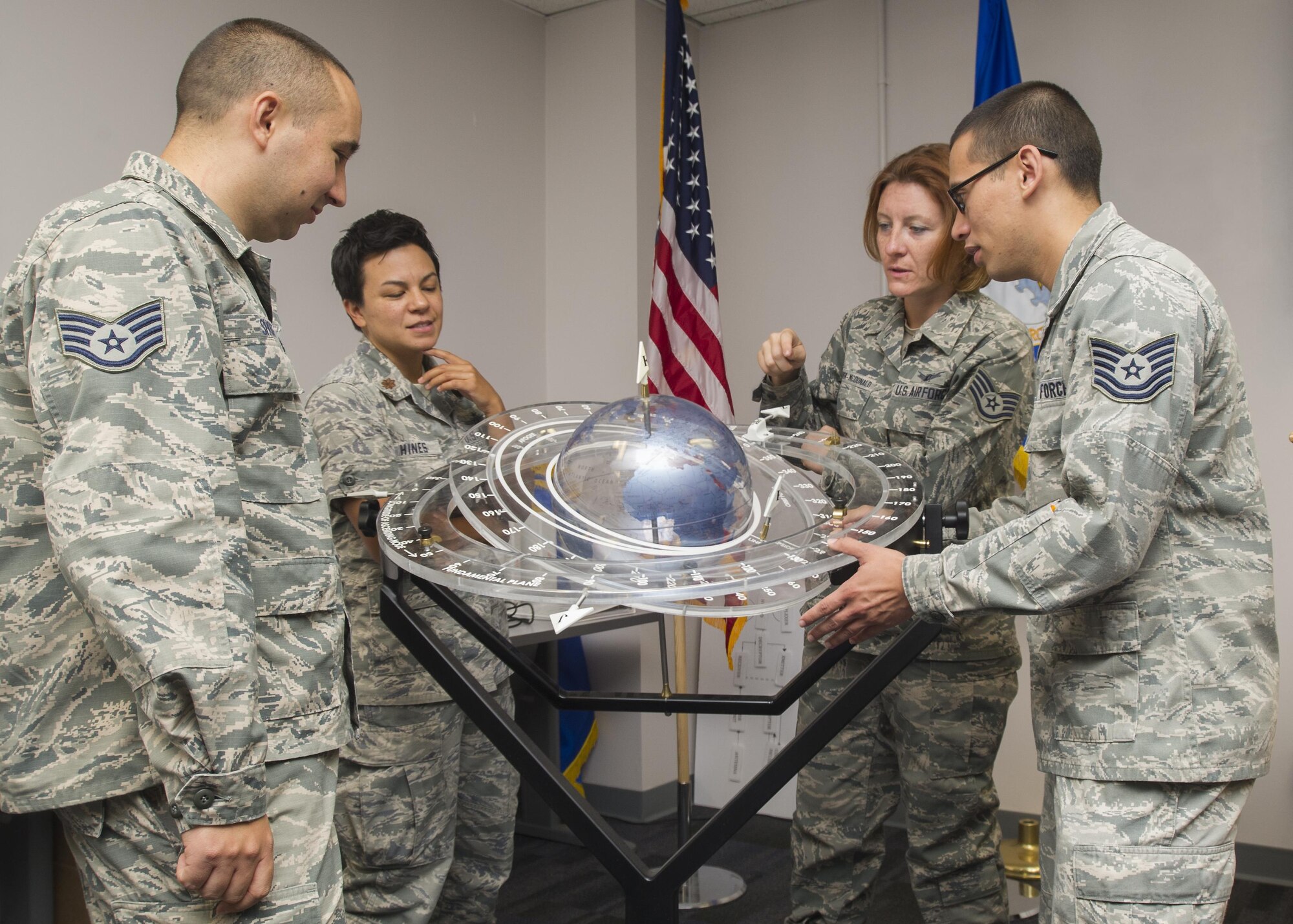 Members of the 310th Operations Support Squadron discuss the tracking of satellites orbiting the earth using a training aid on Saturday, Sep. 9th, 2017.