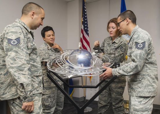 Members of the 310th Operations Support Squadron discuss the tracking of satellites orbiting the earth using a training aid on Saturday, Sep. 9th, 2017.