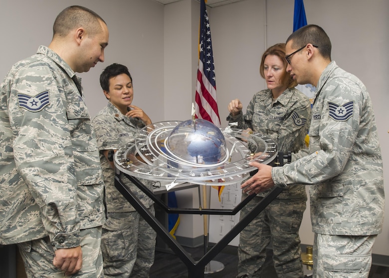 Members of the 310th Operations Support Squadron discuss the tracking of satellites orbiting the earth using a training aid on Saturday, Sep. 9th, 2017.