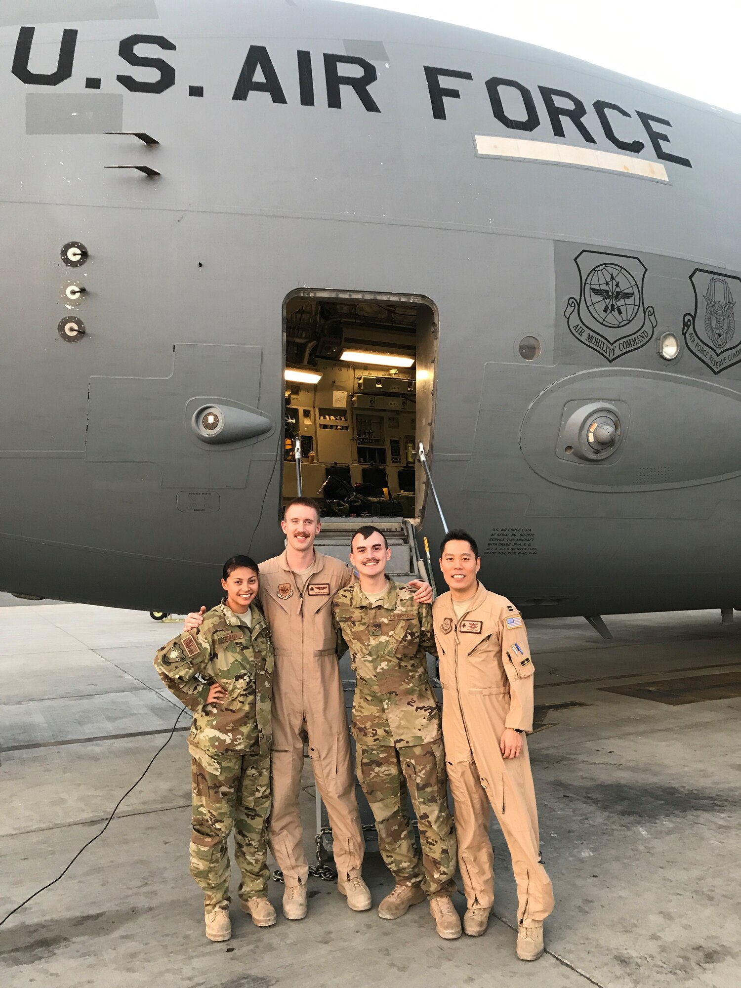 Staff Sgt. Ashley Cardillo, 1st Lt. Steven Roshong, Airman 1st Class Matthew Swift and Capt. Patrick Ng, 816th Expeditionary Airlift Squadron KC-10 Extender flight crew, stand for a photo after an air refueling from a C-17 Globemaster III Aug. 10 over Southwest Asia. The crew and aircraft for both jets originate from Travis Air Force Base, Calif. (Courtesy photo/Staff Sgt. Ashley Cardillo)