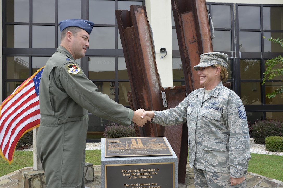 Lt. Col. Brian Lukowski, Director, Space Forces, Continental Aerospace Defense Region-1st Air Force (Air Forces Northern), congratulates Master Sgt. Jamie Jo Walker, U.S. Air Force Space Command training manager, following her taking the oath of reenlistment in front of the 9-11 Memorial at the 601st Air Operations Center, Tyndall Air Force Base, Fla. (Photo by Mary McHale)