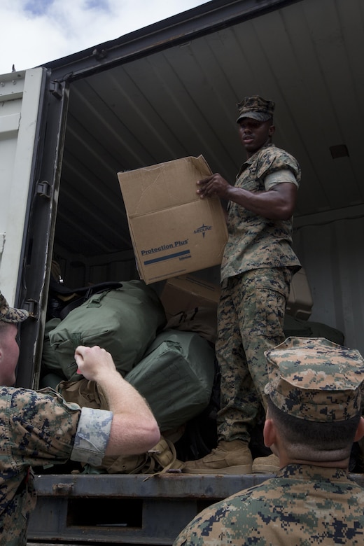 Marines with the 31st Marine Expeditionary Unit move sea bags, packs and gear pier side at White Beach Naval Facility, Okinawa, Japan, June 7, 2017.